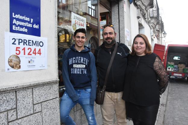 Raúl González ayer junto a su hijo Raúl y su mujer Cristina en el estanco de Alburquerque que vendió el billete de su hermano. :: C. Moreno/