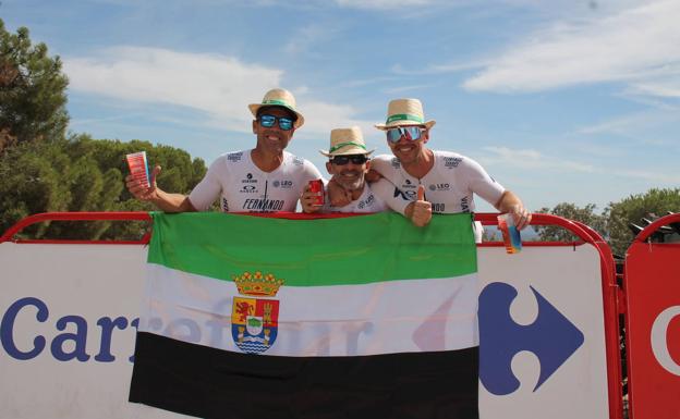 Tres amigos de la AC de Llerena coronaron la cima de Tentudía con la bandera de Extremadura tras cruzar la línea de meta con sus bicis /Isabel Ambrona