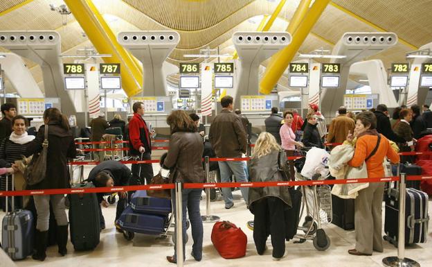 Numerosos viajeros esperan a facturar su maleta en el aeropuerto Madrid-Barajas./EFE