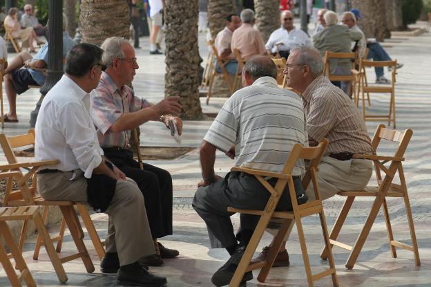 Un grupo de personas de tertulia en una calle de Alicante. :: CARLOS RODRÍGUEZ/