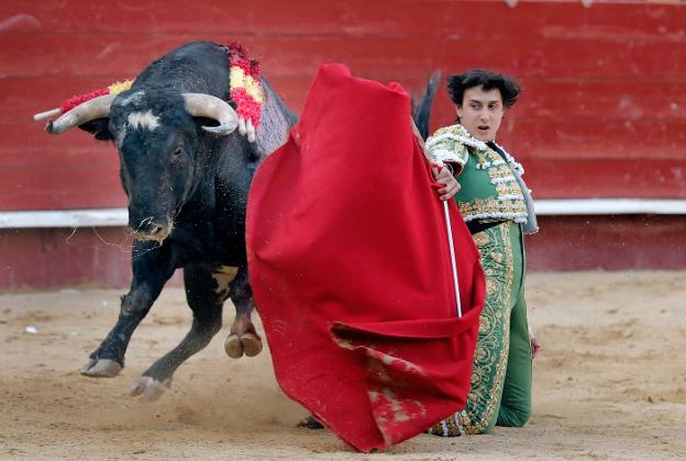 El peruano Andrés Roca Rey da un pase con la muleta al primero de su lote, al que cortó dos orejas. :: efe/