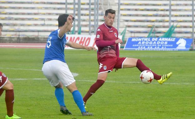 Javi Rey trata de impedir el centro del jugador del San Fernando Lolo Guerrero. :: CATA ZAMBRANO/