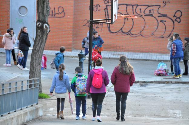 Alumnos y madres a la entrada de un centro educativo de la ciudad. :: david palma/