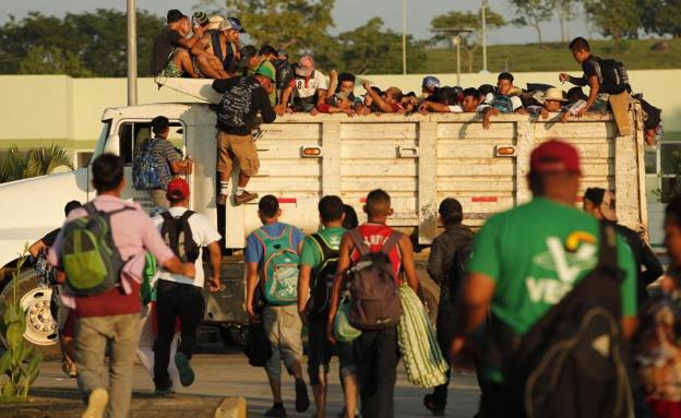 Migrantes hondureños suben a un camión./EFE