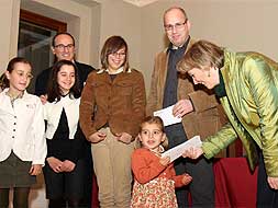 Una niña entrega la ayuda a una directiva de la asociación. / A. SOLÉ/