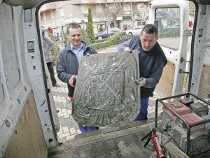 Operarios municipales retiran el escudo el 25 de marzo. :: HOY/