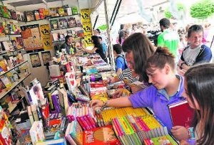 Varios jóvenes ojean los títulos expuesto en un stand de la feria. :: JOSÉ VICENTE ARNELAS/