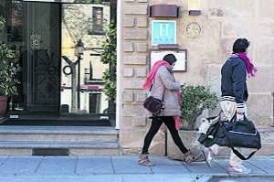 Dos turistas, ayer a su salida del hotel NH Palacio de Oquendo, situado en la Plaza de San Juan. :: LORENZO CORDERO/