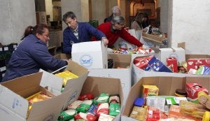 Voluntarios del Banco de Alimentos trabajando ayer por la noche en la clasificación de comida en el silo de Aldea Moret. :: MARISA NÚÑEZ/