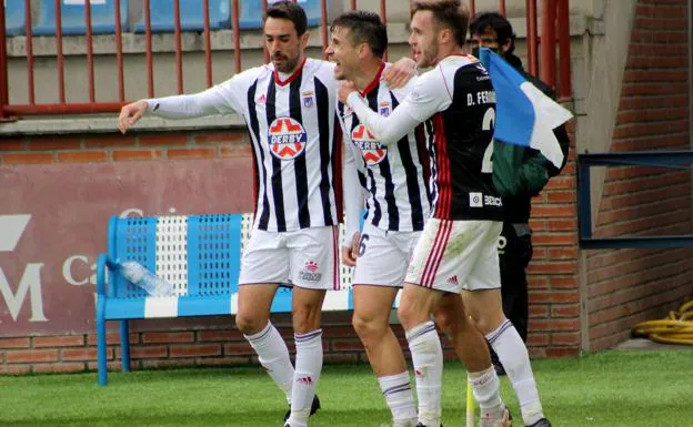 Guzmán y Dani Fernández felicitan a Dani Aquino, que marcó un espectacular gol que supuso el 2-0 para el Badajoz./M. Camacho