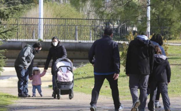 Una pareja con una niña y un grupo de personas paseando por Mérida. /J. M. Romero