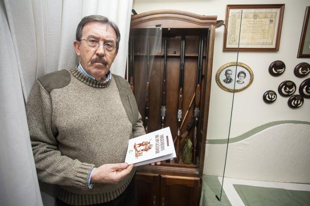Salvador Calvo con sus escopetas de caza y su último libro. / JORGE REY