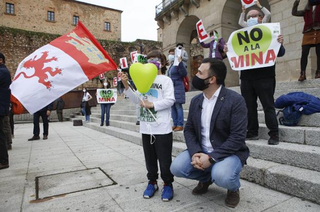 Luis Salaya junto a un niño que ondea la bandera de Cáceres en una reciente concentración contra la mina. / HOY