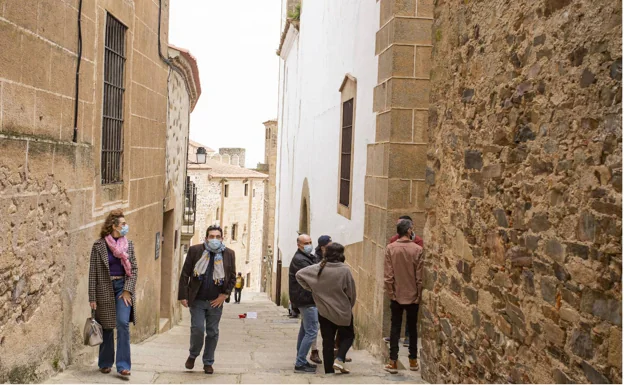 Turistas en la Cuesta de la Compañía y el callejón de Don Álvaro de la Ciudad Monumental cacereña, este Jueves Santo por la mañana. /jorge rey