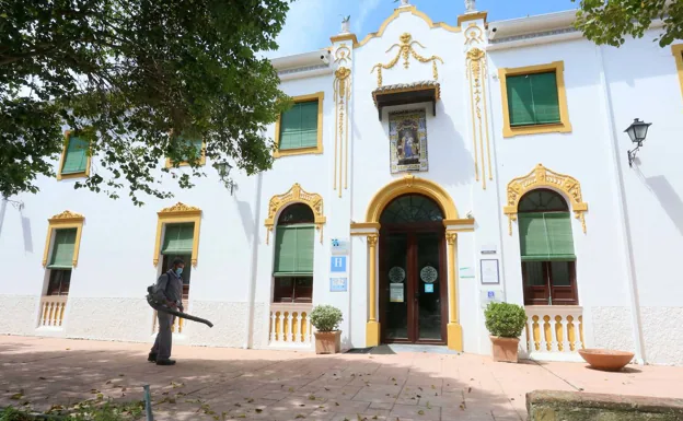 Un trabajador limpia de hojas la entrada del hotel junto al balneario de El Raposo, en el término de Puebla de Sancho Pérez. Los servicios del balneario se reinician hoy. /J. M. Romero