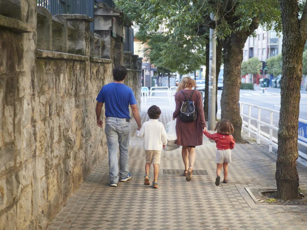 Unos padres con sus hijos por la calle. / HOY