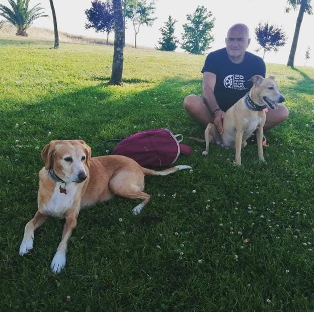 En el campo.Rebollo con Teo y Nelly, los dos perros que adoptó recién nacidos en el Refugio. / HOY