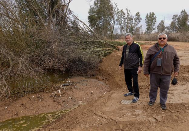 José Manuel Rodríguez y Juan Fernando Delgado señalan vertidos de plásticos en el río. / C. MORENO