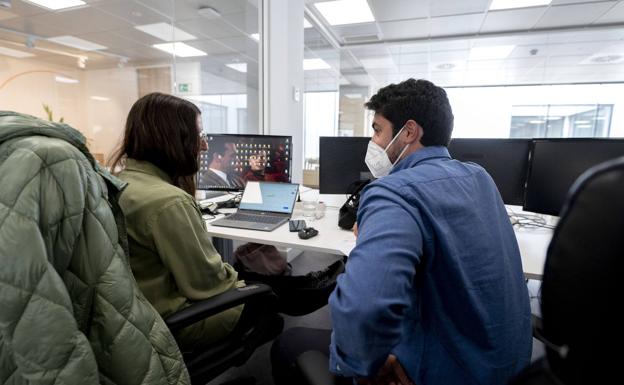 Dos empleados, en sus puestos de trabajo./ep