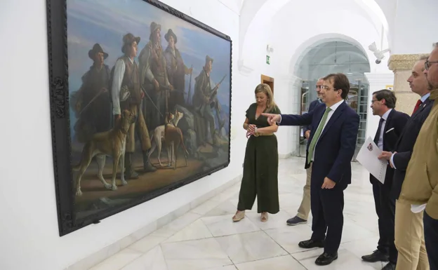 El primer ministro;  los presidentes de los dos consejos;  el presidente de la Asamblea;  el presidente de la Federación de Cazadores y el alcalde de Mérida contemplan el cuadro 'Los aguiluchos', de Adelardo Covarsí. 