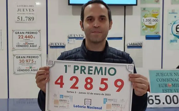 Diego Marín sostiene el cartel con el número ganador en la mano.